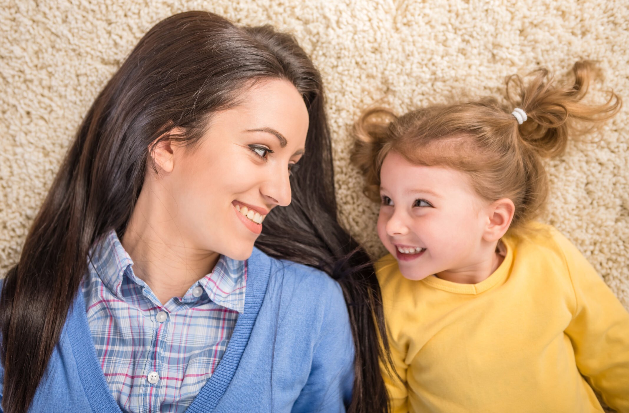 Mom daughter laying looking at each other smiling - Vadimgozhda